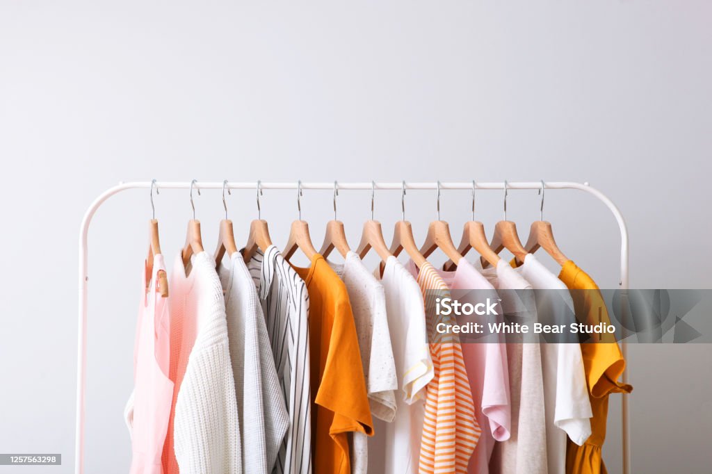 fashion clothes on a rack in a light background indoors. place for text Clothing Stock Photo