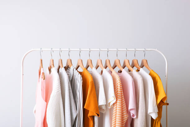 fashion clothes on a rack in a light background indoors. place for text - moda imagens e fotografias de stock