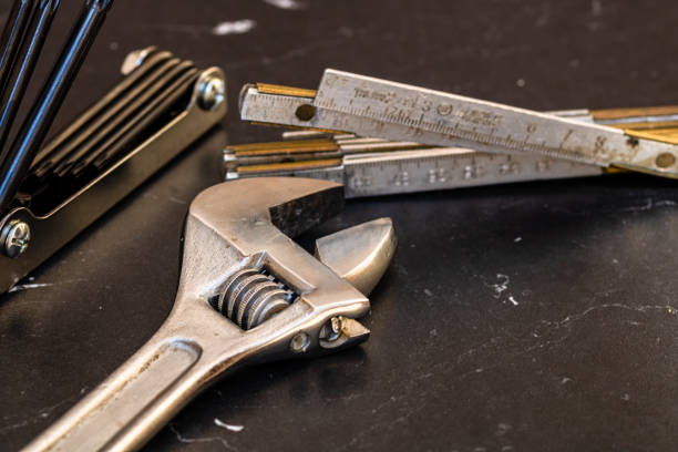 istock Tools for repair and building. Adjustable spanner, ruler and instruments on black wooden table with copy space 1257564424