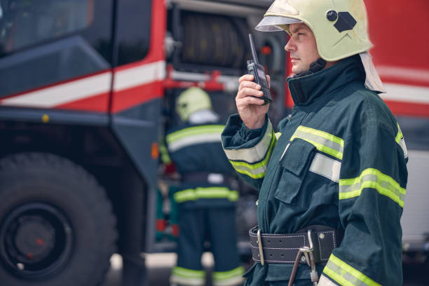 istock Man wearing helmet and protective uniform holding walkie in hand 1257565027