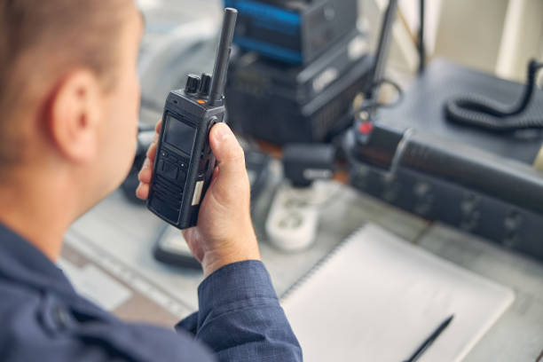 Cheerful adult male looking down while saying on the walkie talkie stock photo