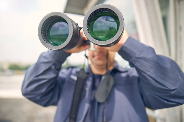 istock Handsome adult man looking away through binoculars 1257565081