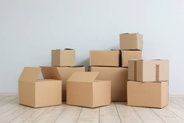 istock Cardboard boxes and household stuff in empty room. Moving day 1257565308
