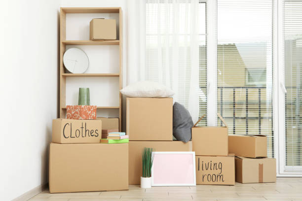 istock Cardboard boxes and household stuff in empty room. Moving day 1257565352