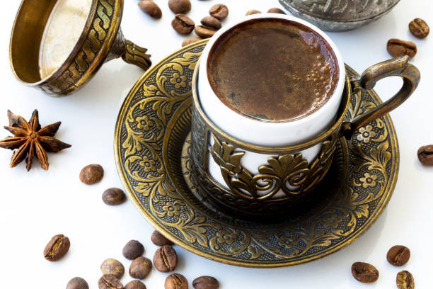 Turkish coffee with roasted coffee beans and traditional copper serving set on white background stock photo