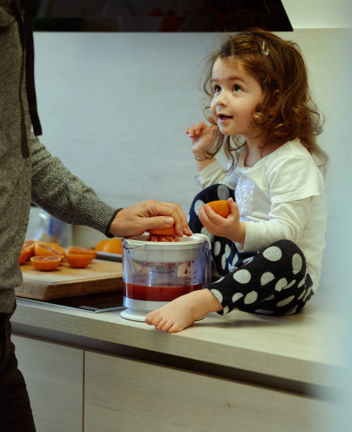 istock Baby girl juicing grapefruit with dad 1257568075
