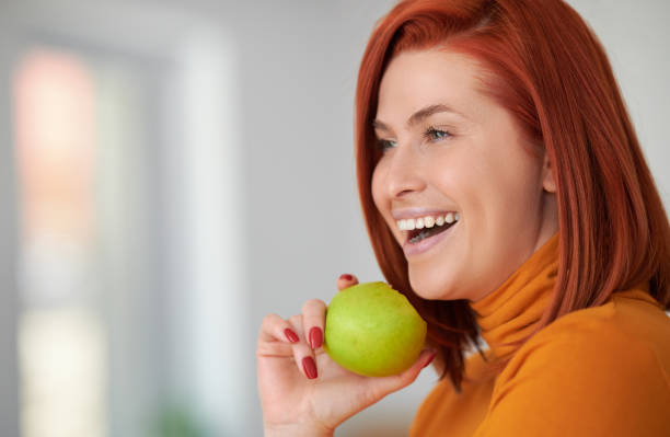 Beautiful redhead holding green apple