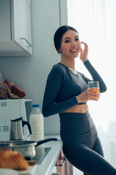 istock Pretty lady standing in the kitchen in sporty clothes 1257570033