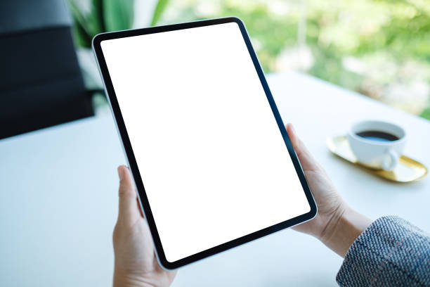 istock a woman holding tablet pc with blank white desktop screen in the office 1257570170