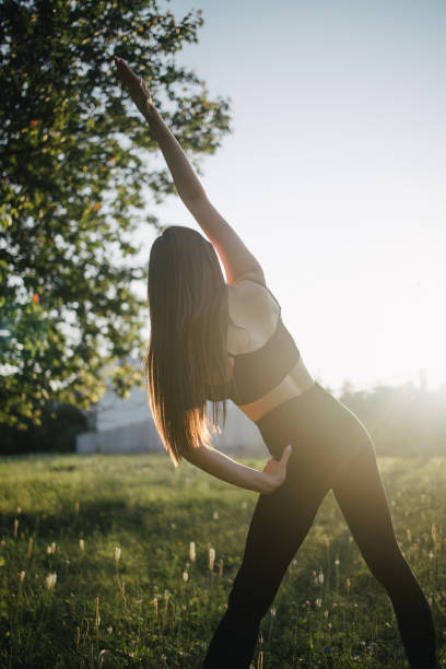 istock Young woman doing exercises outdoors, back view 1257570990