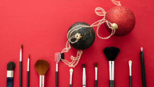 istock Make-up brushes and xmas decoration against red background, copy space 1257571586