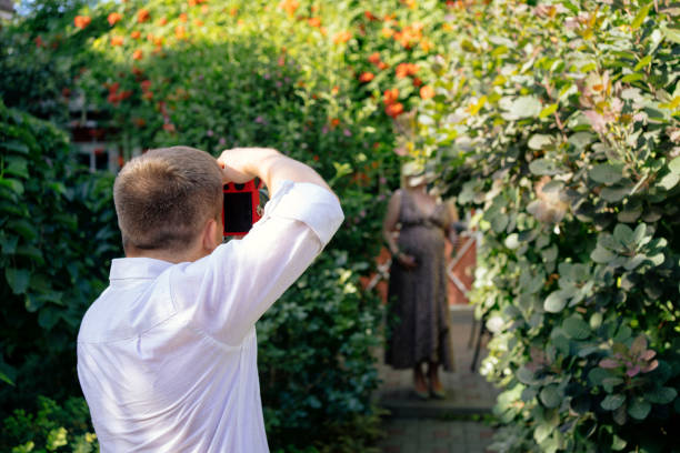 backstage photo shoot pregnancy in the garden. the photographer makes shooting model in anticipation of the baby.