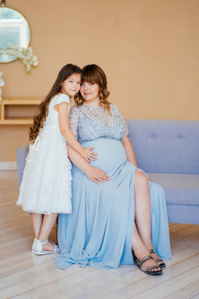 istock pregnant sitting on couch with daughter 1257572646