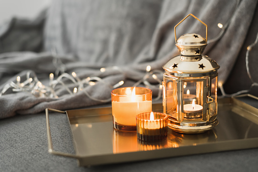 Metal lantern and burning candles on a golden metal tray. Eid al Adha celebration. Muslim holiday atmosphere