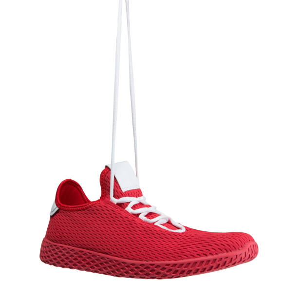 istock red sneaker made of mesh fabric, hung on laces, concept, on a white background 1257575423