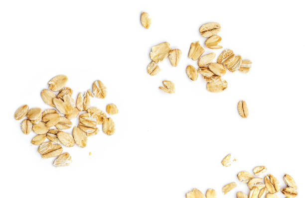 escamas de avena aisladas sobre fondo blanco. pile of oatmeal top view"n - oat wheat oatmeal cereal plant fotografías e imágenes de stock