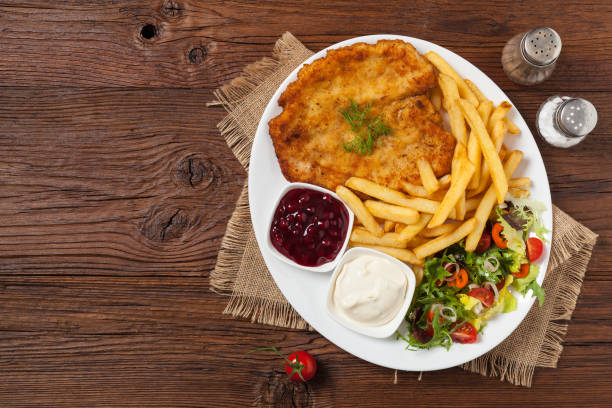 istock Chicken schnitzel, served with fries and salad. 1257576946
