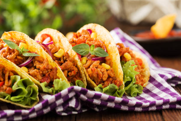 istock Tacos with meat and vegetables on wooden board 1257577237