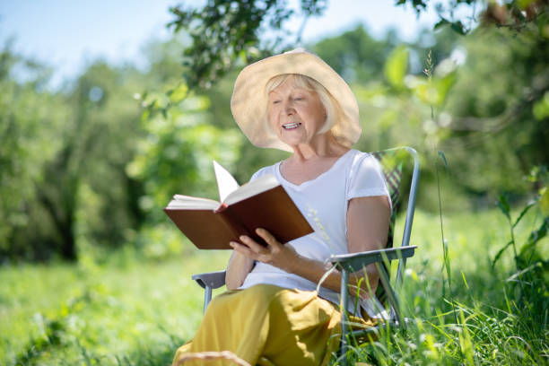 istock Woman reading a book sitting in a deck chair 1257577359