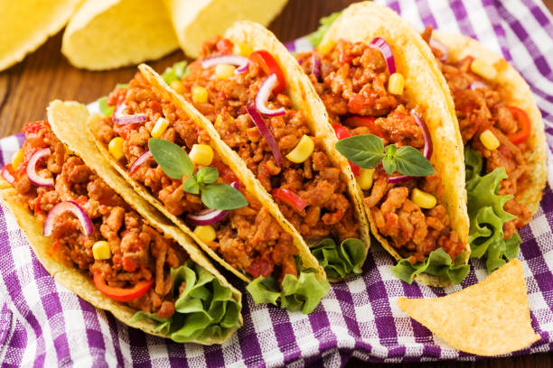 istock Tacos with meat and vegetables on wooden board 1257578081