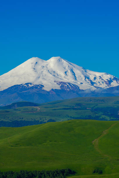 Amazing Elbrus and Green Meadow Hills at a Summer Day. North Caucasus, Karachay-Cherkessia, Russia, Vertical