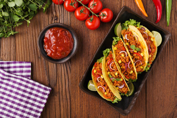 istock Tacos with meat and vegetables on wooden board 1257578411