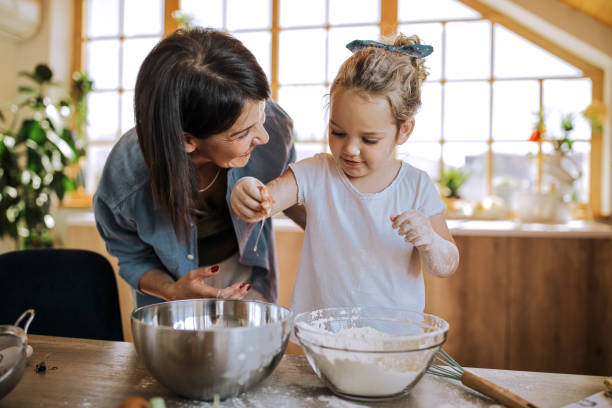 istock Cute little girl cracking egg in the kitchen 1257578472