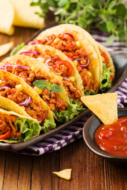 istock Tacos with meat and vegetables on wooden board 1257578730