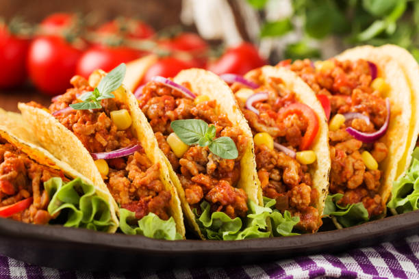 istock Tacos with meat and vegetables on wooden board 1257578764