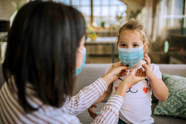 istock Mother putting protective mask on her daughter`s face 1257578772
