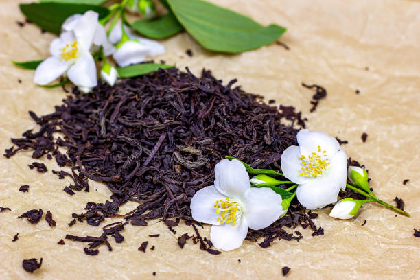 新鮮な有機芳香族ドライ紅茶は、光の背景に白いジャスミンの花とヒープを葉 - tea tea leaves jasmine tea leaf ストックフォトと画像