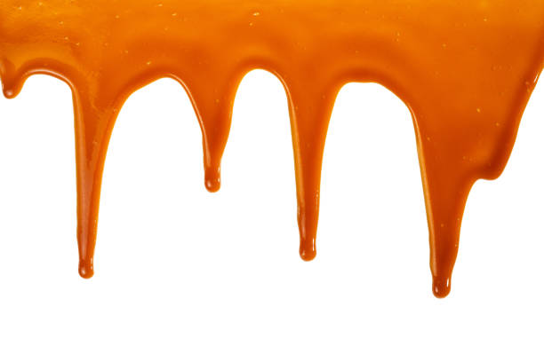 istock Background of flowing caramel sauce isolated on white. 1257581399