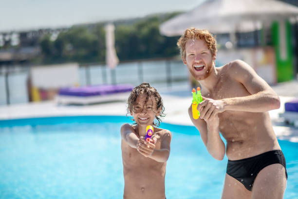istock Wet and funny dad with son with water gun 1257581962