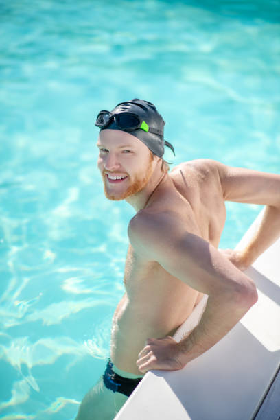 istock Satisfied man standing in water in pool 1257581993