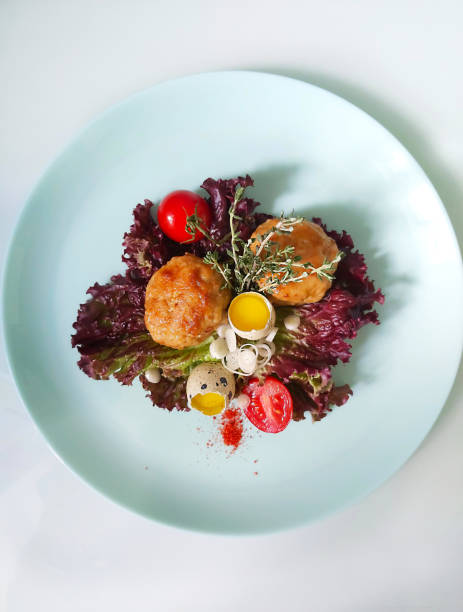 istock A dish with fried cutlets and quail eggs and garnished with greens and cherry tomatoes 1257583027