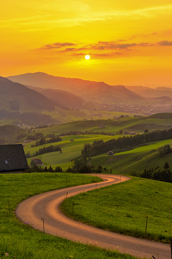 Winding road with view on the countryside at sunset, Appenzell, Switzerland.