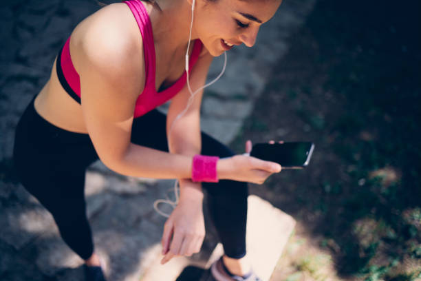 istock Young attractive female runner taking a break after running and using smart phone. 1257583249