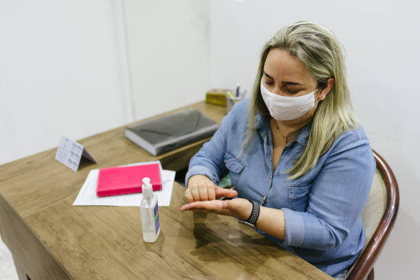 new normal: woman hand sanitizing in the office - 3498 imagens e fotografias de stock