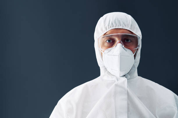 istock Doctor in protective medical suit with copy space on black background 1257583497