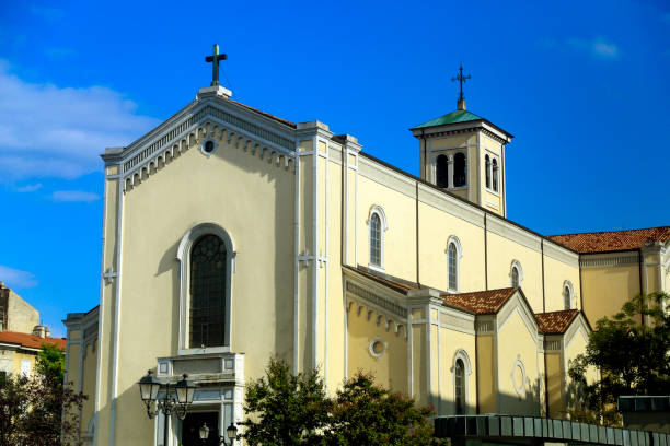 Grassy land leading towards Madonna del Sasso sanctuary against cloudy sky in Piedmont, Italy