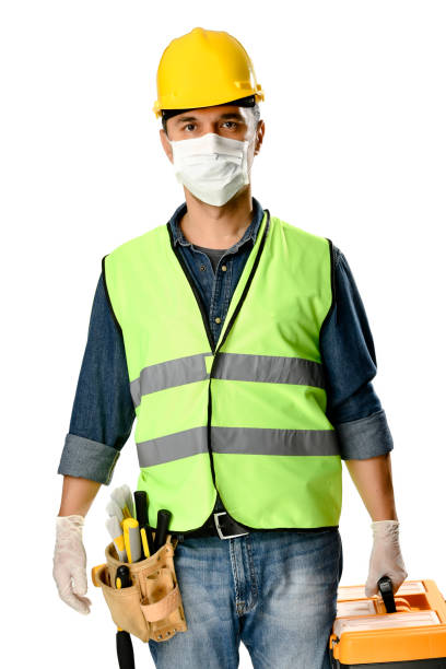 白い背景に隔離されたコロナウイルスの流行を避けるために保護フェイスマスクと手袋を身に着けているツールバッグを持つ手動労働者。 - home improvement carpentry construction work tool ストックフォトと画像