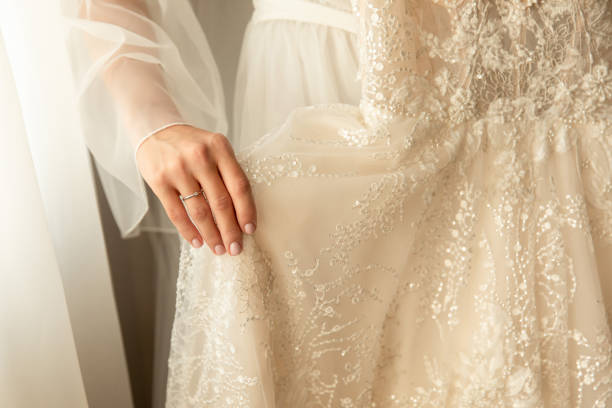 istock Bride holding wedding dress at wedding day 1257588673