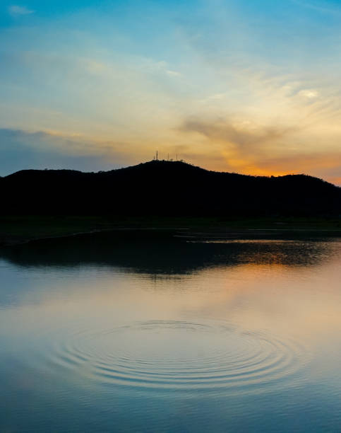 istock Dramatic sky at silhouette mountain with wave at water surface foreground 1257590137