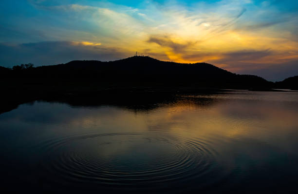 istock Dramatic sky at silhouette mountain with wave at water surface foreground, Landscape background 1257590156