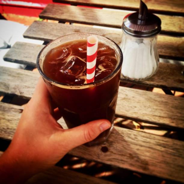 istock Ice coffee in a glass with a red and white paper straw 1257591963