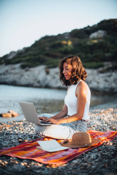 istock Woman Working on Laptop at Seaside 1257593470