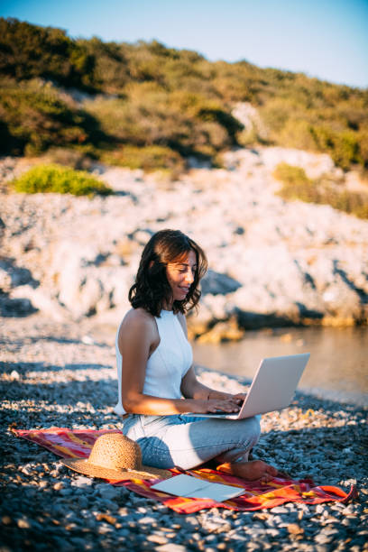 istock Woman Working on Laptop at Seaside 1257593711