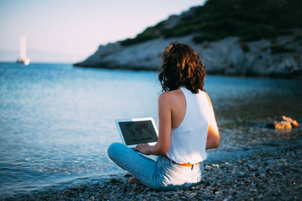 istock Woman Working on Laptop at Seaside 1257596270