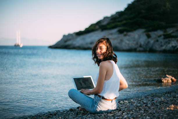 istock Woman Working on Laptop at Seaside 1257596618