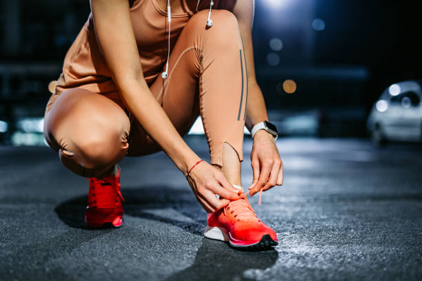 Tying shoelace on running shoes before practice